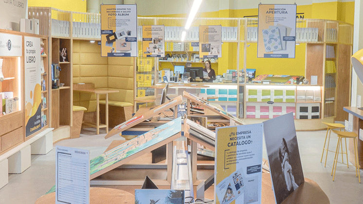 Photo d'une boutique de photocopie avec des supports sur une table et pleins d'affiches aux murs