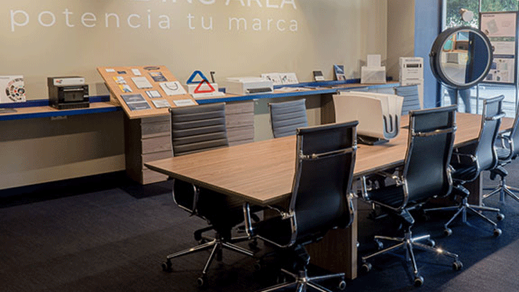 Cette photo est l'intérieur d'un bureau d'entreprise ou l'on voit des produits de la gamme Unibind Peleman, dont un Unibinder 8.4 posé sur une table de réunion