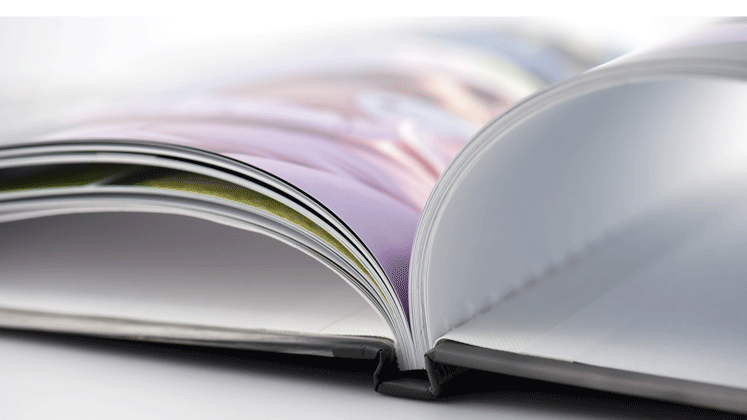 Gros plan sur un livre ouvert montrant bien le système de reliure dos carré collé